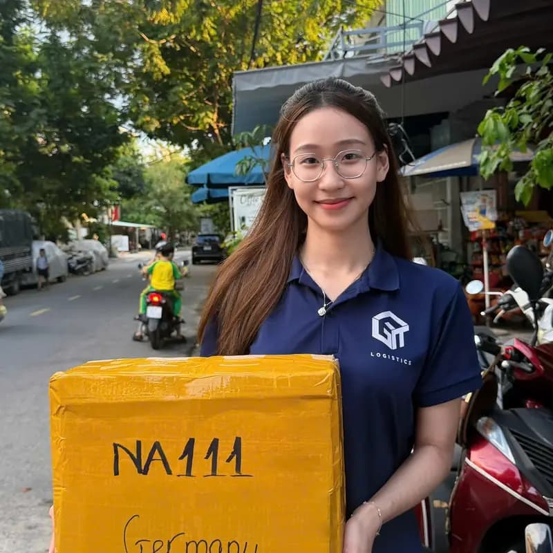 Nhân viên cầm thùng hàng gửi đi Đức