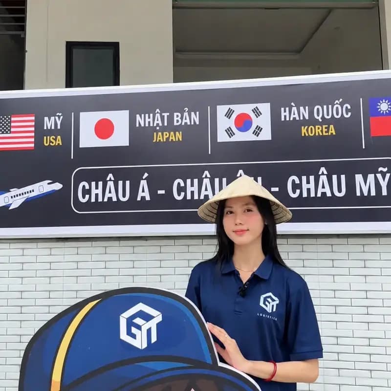 Nhân viên GT Logistics bên linh vật công ty và bảng tuyến Mỹ, Nhật Bản, Hàn Quốc